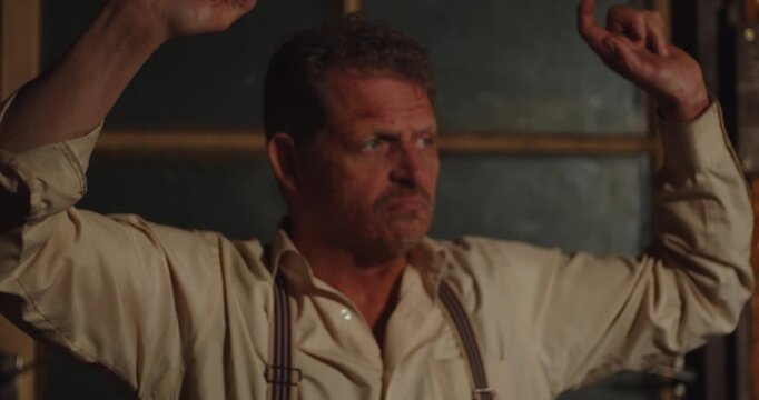 An prohibition era gangster puts up his hands in the air and surrenders