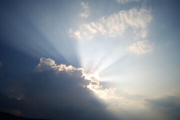 Dramatic sky with sun ray shining over the mountain in the evening	