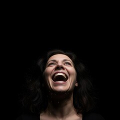 Dramatic Portrait of a Joyful Woman Laughing with Water Droplets on a Dark Black Background