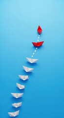 Red paper boat leads white boats in blue water
