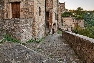 Sorano, Grosseto, Tuscany, Italy: a view of a medieval stone alley along the ancient city walls, overlooking the Lente valley forest
