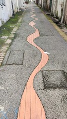 Winding Pathway in an Alley. A quiet alleyway featuring a unique winding brick path that guides the way forward.