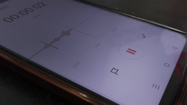 A woman's hand turns on the recording on a voice recorder on the phone. Audio recording for testimony