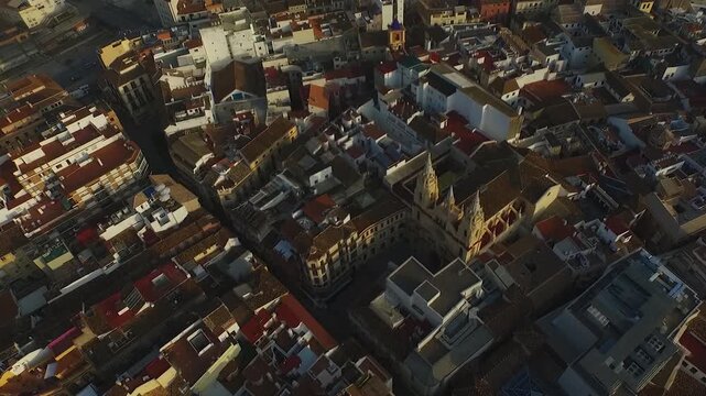 High drone view descending into a top-down shot over Iglesia del Sagrado Coraz&oacute;n in M&aacute;laga, surrounded by dense historic rooftops.