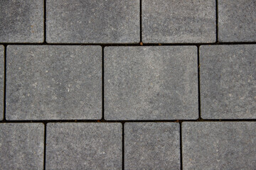 Obraz premium Gray stone pavers arranged in a geometric pattern, showcasing texture and durability, ideal for outdoor pathways and landscaping design concepts with copy space