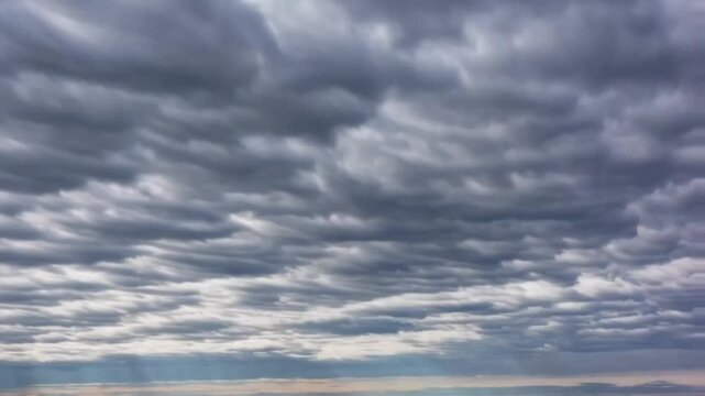 Dramatic 4K timelapse captures dark clouds overtaking the sky, highlighting intense weather changes, ominous atmosphere, and powerful storm dynamics