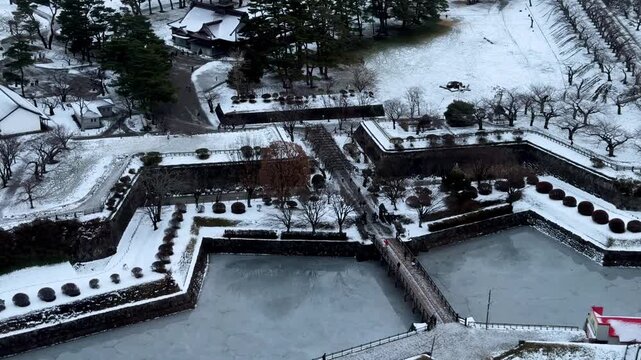 Snow covered historic fort walls and frozen moat viewed from above