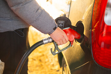 Filling up a car with gasoline at a fuel station during daylight hours. Man hand refuel the car © Mykola