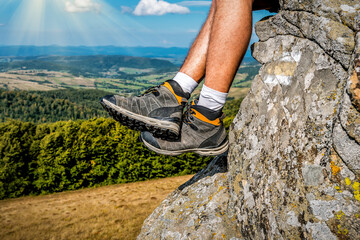 Legs in comfortable hiking boots in sunny mountains