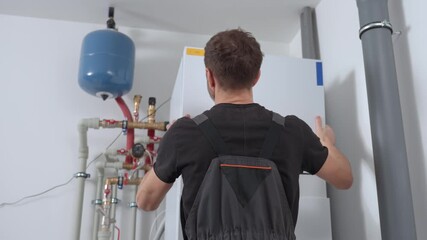 Technician open control panel with internal wiring to inspecting heat pump unit. Specialist servicing heating and cooling system. Concept of HVAC maintenance, home heating system and energy efficiency