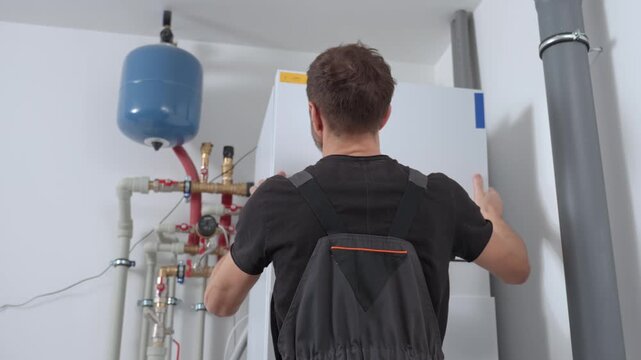 Technician open control panel with internal wiring to inspecting heat pump unit. Specialist servicing heating and cooling system. Concept of HVAC maintenance, home heating system and energy efficiency