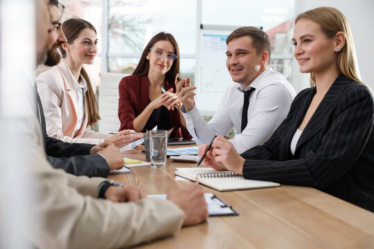 Team of businesspeople working together at table in office - Powered by Adobe