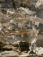 dark brown marble texture with white veins and wavy patterns. Polished natural stone surface for luxury interior design and architectural background