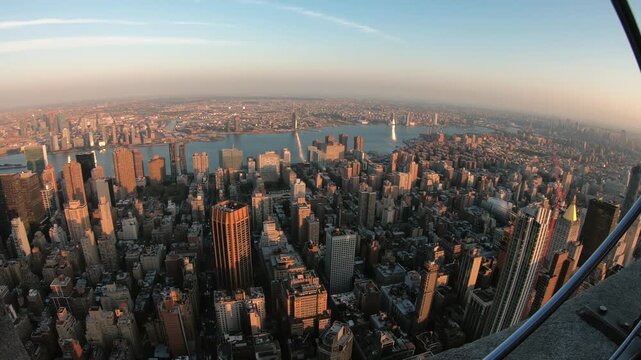 Sunset aerial view capturing the dense architecture of Manhattan with the East River beyond
