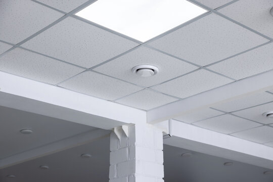 Tiled ceiling with lighting indoors, low angle view