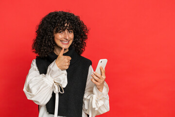 Young woman use smartphone typing new post on web browsing searching addiction of social networks positive feedback recommends wifi cellular connection 5G showing pointing advertising. Red background