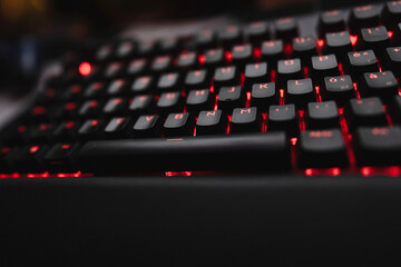 Gaming keyboard displaying red backlit keys in dark environment