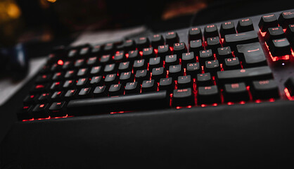 Backlit gaming keyboard with red illumination in dark setting