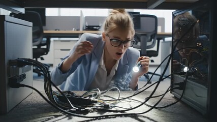 It Technician Investigating Computer Cables Under Desk With Flashlight
