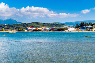 Fototapeta premium Sidari beach with tourists, mountainous landscape of Corfu in background, Greek paradise.