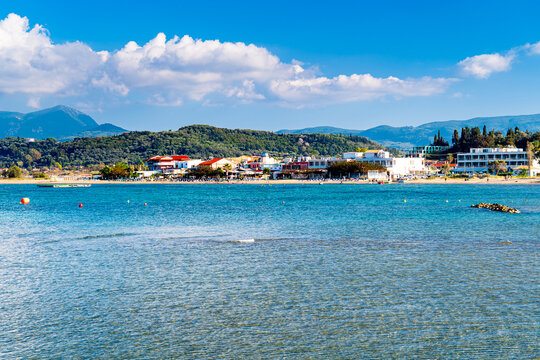 Sidari beach with tourists, mountainous landscape of Corfu in background, Greek paradise.