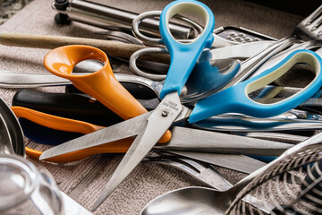Kitchen scissors and cutlery cluttered in a drawer