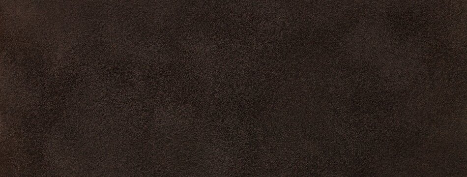Dark brown suede fabric background with matte velvet texture, chocolate tones and soft felt surface in macro