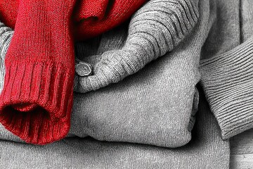 Folded knits, red accent. Monochromatic except bright crimson