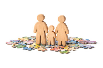 Wooden family figures of parents and child standing on colorful puzzle pieces, concept of autism support, inclusion, parenting and neurodiversity