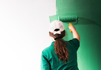 Young women painting a wall with paint roller