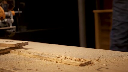 Woodworking machine cutting raw timber on workshop table with fresh sawdust showing carpentry process precision tools and manual craftsmanship