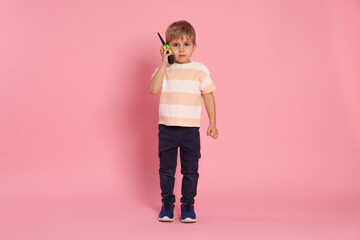 Cute little boy with radio on pink background © New Africa