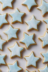 Light blue star-shaped iced cookies arranged on a light beige surface