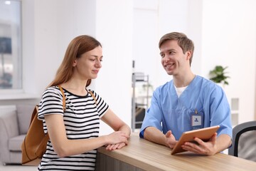 Obraz premium Medical assistant helping patient at reception in clinic
