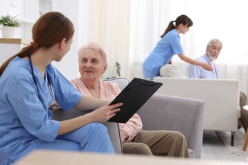 Obraz premium Care worker asking senior woman about her wellbeing at retirement home