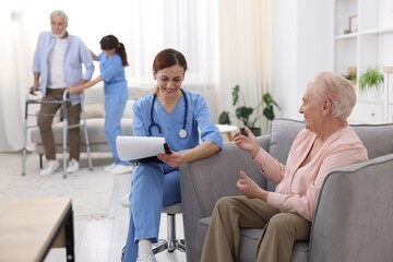 Obraz premium Care worker asking senior woman about her wellbeing at retirement home