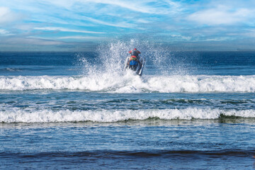 Jet Ski Rider Creating Dramatic Splash on Ocean Waves Under Clear Blue Sky, Agadir Morocco