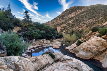 Serene Rocky Canyon Oasis With Pool, Trees, and Mountain Backdrop Under Blue Sky, Tizguan, Agadir, Morocco
