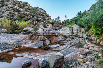 Serene Rocky Canyon Oasis With Pool, Trees, and Mountain Backdrop Under Blue Sky, Tizguan, Agadir, Morocco
