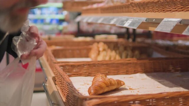 A Caucasian man puts pieces of pastry into a plastic bag