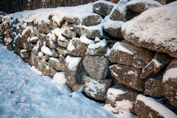 section of old snowy stone wall outdoors