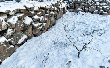 section of old snowy stone wall outdoors