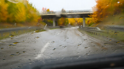 Driving in wet conditions, rain and poor visibility. Wetness on the windscreen in bad weather with oncoming traffic and speed limit.