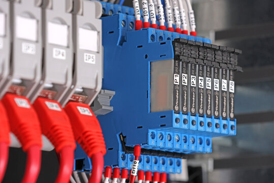 Ultra-thin intermediate relays with a connection terminal block from Finder during the assembly of an electrical panel. 