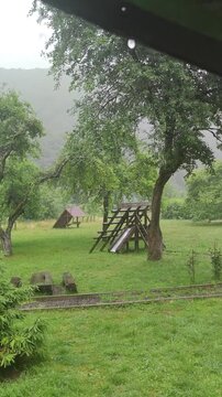 a storm in a Carpathian mountain village near Rakhiv, Ukraine. Strong winds break trees, pouring rain falls, a wall of water crashes onto a Hutsul pasture.