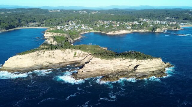 Drone aerial landscape of bushland trees and hiking trails covering cliff face overlooking ocean cove at Pretty Point headland coastline in Malua Bay South Coast Australia travel tourism holidays