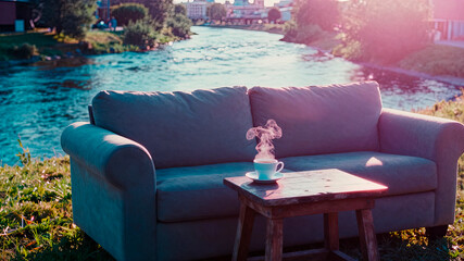 a secluded place for relaxing with a sofa, armchair, and table by the river