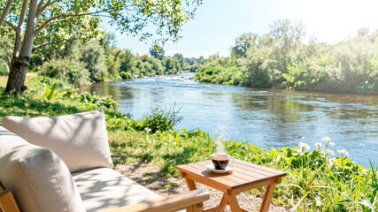 a secluded place for relaxing with a sofa, armchair, and table by the river