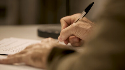 Obraz premium A man hands are examining a document with a pen. Office work