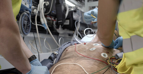 A man is receiving emergency medical attention inside an ambulance. © Kiromedia